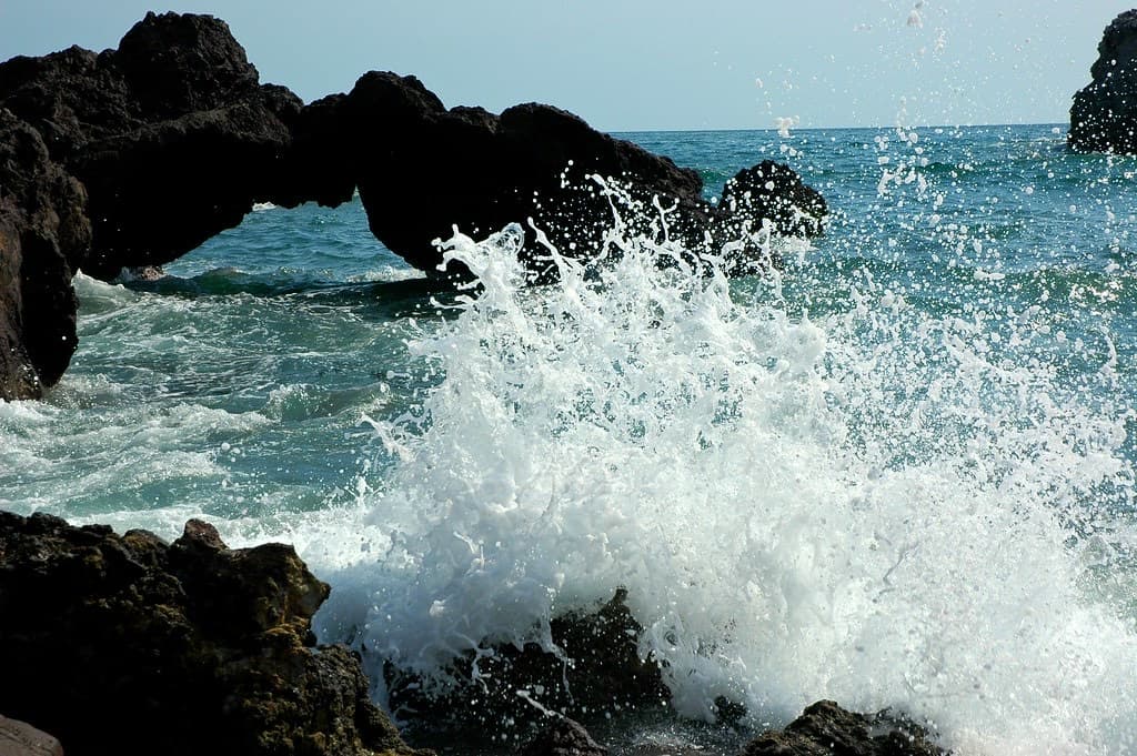 Una ola rompiendo contra las rocas